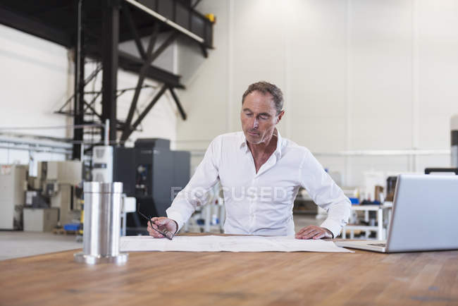 Man examining plan at table — Stock Photo