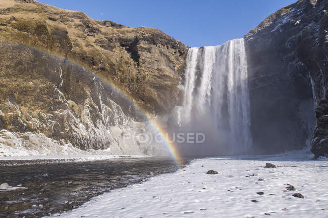 Водоспад скооафосс з веселкою взимку — стокове фото