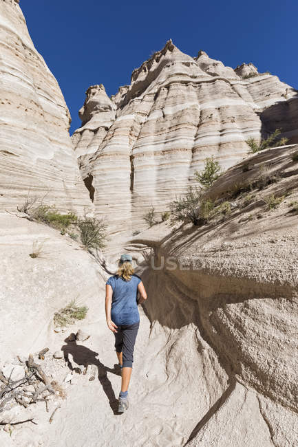США, Нью-Мексико, Плато Паджарито, округ Сандовал, Национальный памятник палаточных скал Каша-Катуве, турист в долине пустыни с причудливыми скалами — стоковое фото