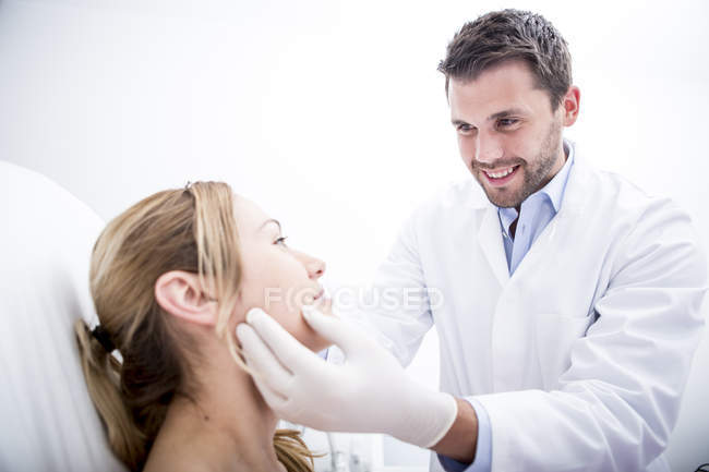 Doctor examining woman at surgery — Stock Photo