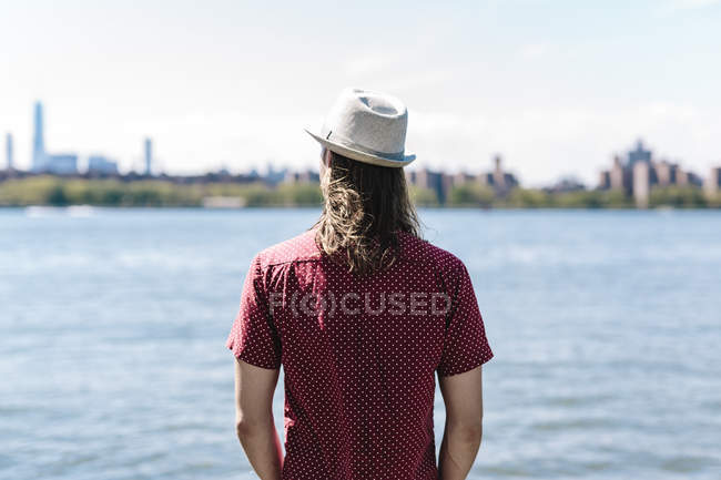 Задний портрет среднего взрослого мужчины, стоящего на берегу реки — стоковое фото