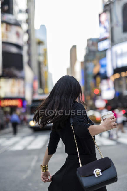 Ritratto di giovane donna con tazza usa e getta in strada — Foto stock