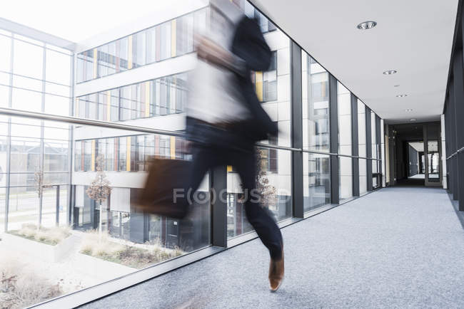 Verschwommene Sicht auf Geschäftsmann, der in Hausflur läuft — Stockfoto