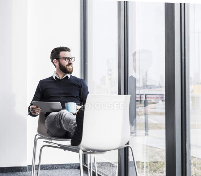 Porträt eines jungen Geschäftsmannes mit Tablet am Fenster — Stockfoto