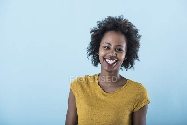 Porträt einer glücklichen jungen Frau auf blauem Hintergrund — Stockfoto