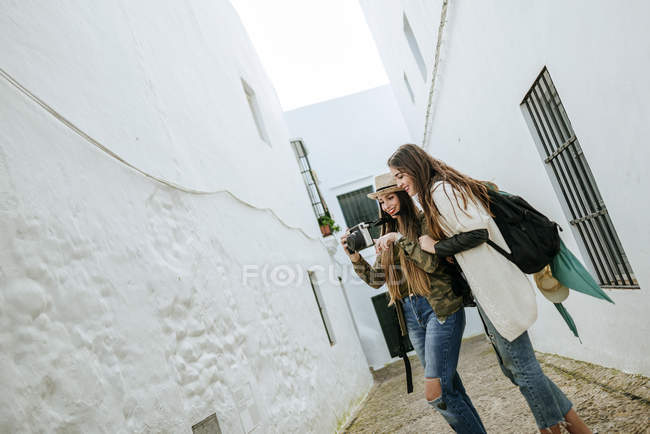 Giovani viaggiatori femminili che guardano le foto in una macchina fotografica — Foto stock