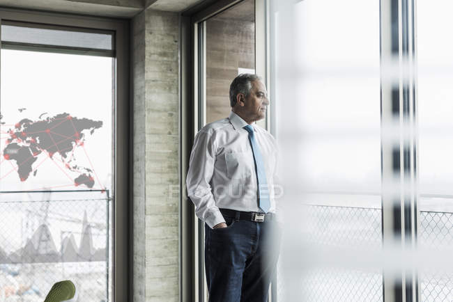 Portrait of senior businessman standing by window — Stock Photo