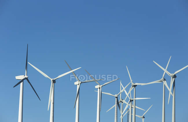 White wind turbines and blue sky on background — Stock Photo