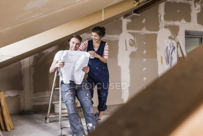 Ritratto di giovane coppia guardando piano di costruzione — Foto stock
