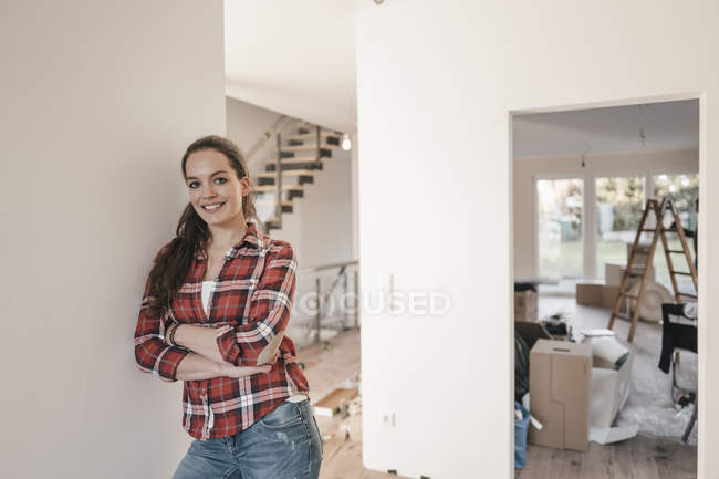 Reife Frau steht im neuen Zuhause, an Wand gelehnt — Stockfoto