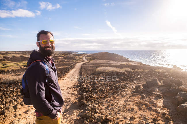 Espanha, Tenerife, retrato de caminhante feliz em pé no caminho à luz do sol — Fotografia de Stock