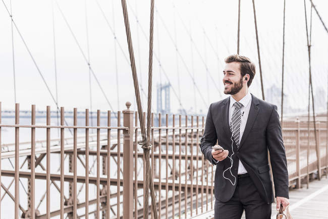 USA, new york, brooklyn bridge, junger unternehmer spaziert beiseite — Stockfoto
