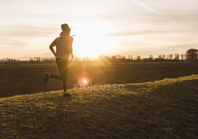 Портрет молодого человека, бегущего в поле — стоковое фото