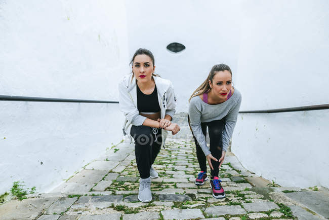 Две женщины делают упражнения на растяжку ног на улице
. — стоковое фото