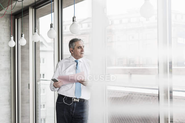 Manager mit Dokument am Fenster — Stockfoto