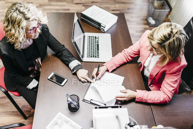 Due imprenditrici che lavorano al documento in carica — Foto stock