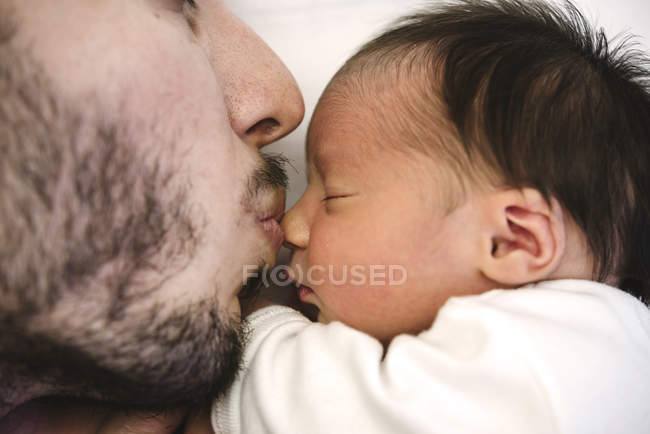Primer plano de padre besar bebé recién nacido niña - foto de stock