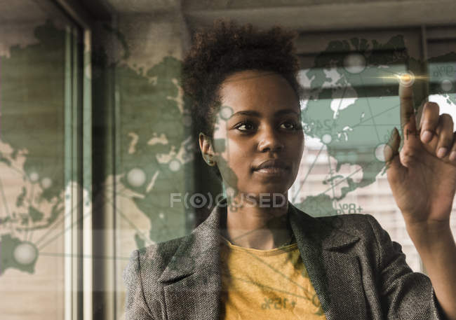 Portrait of young businesswoman touching glass screen — Stock Photo