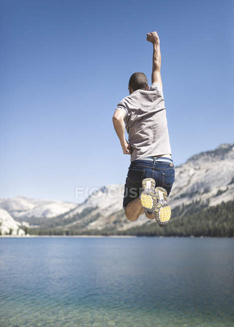 USA, California, Parco Nazionale dello Yosemite, uomo che salta in aria al lago di montagna — Foto stock