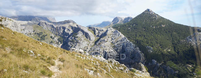 Вид на скалы и скалы с травой в дневное время, Испания — стоковое фото