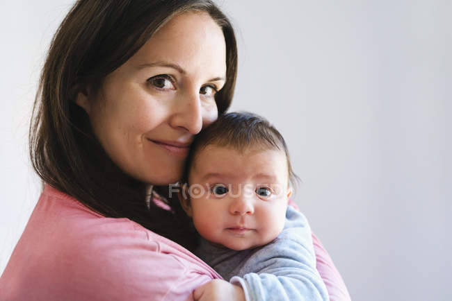 Felice madre in possesso di un bambino carino — Foto stock