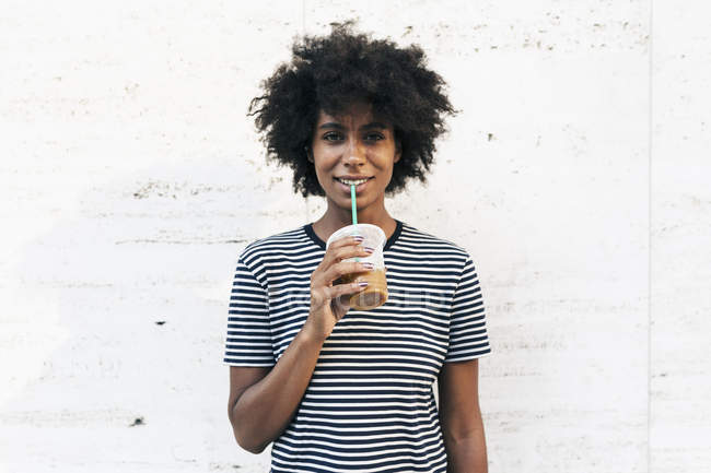 Jeune femme afro-américaine attrayante boire une boisson de tasse par paille — Photo de stock