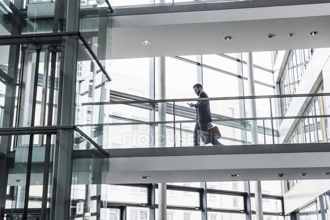 Porträt eines jungen Geschäftsmannes mit Smartphone im Hausflur — Stockfoto