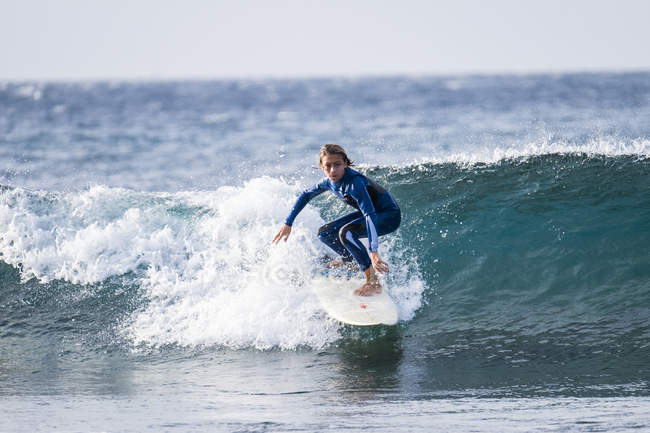 Adolescente surfeando en olas en el mar - foto de stock