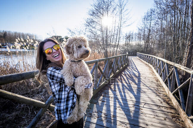 Mujer feliz en gafas de sol con perro - foto de stock
