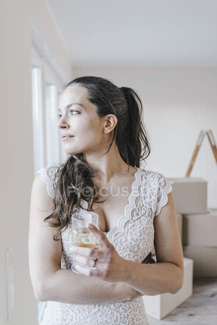 Reife Geschäftsfrau steht mit Glas Wasser im neuen Zuhause — Stockfoto