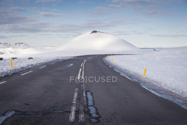 Vista di strada vuota e neve sullo sfondo durante il giorno — Foto stock