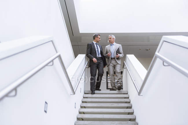 Empresários descendo as escadas — Fotografia de Stock