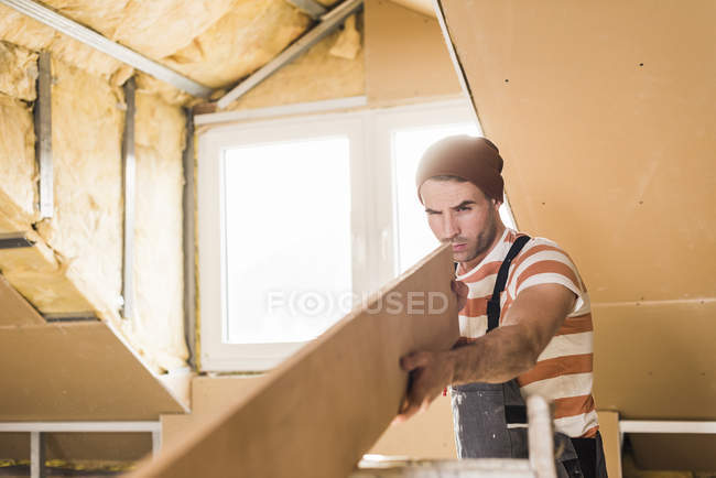 Portrait of young man checking wooden plank — Stock Photo