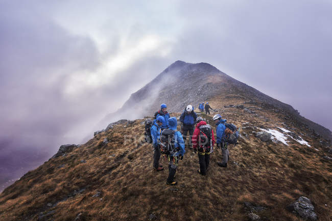 Nepal, Himalayas, Khumbu, Everest region. Trekkers standing on misty mountain range — Stock Photo
