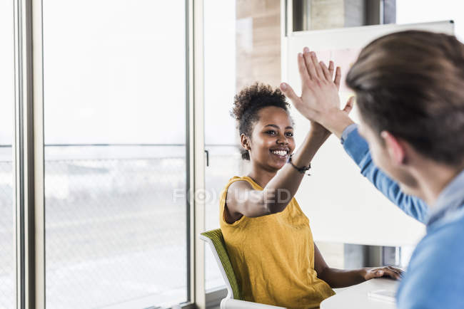 Porträt junger Geschäftskollegen High Fiving — Stockfoto