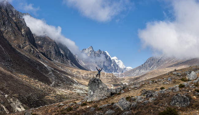 Nepal, Himalaya, Khumbu, Everest region, Khunde, woman cheering on rock — Stock Photo