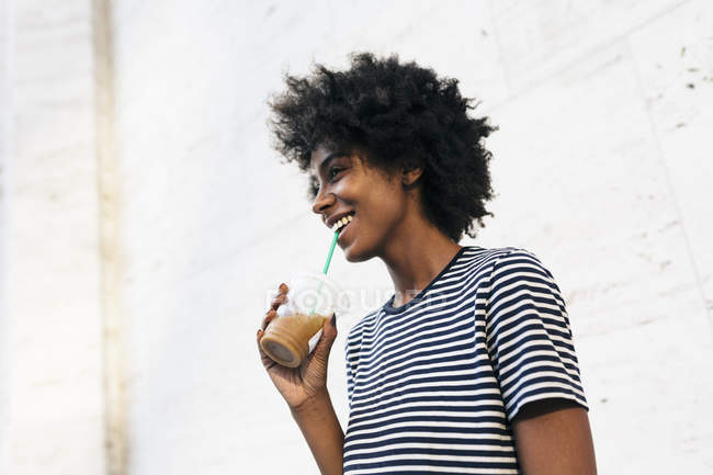 Jeune femme afro-américaine attrayante boire une boisson de tasse par paille — Photo de stock