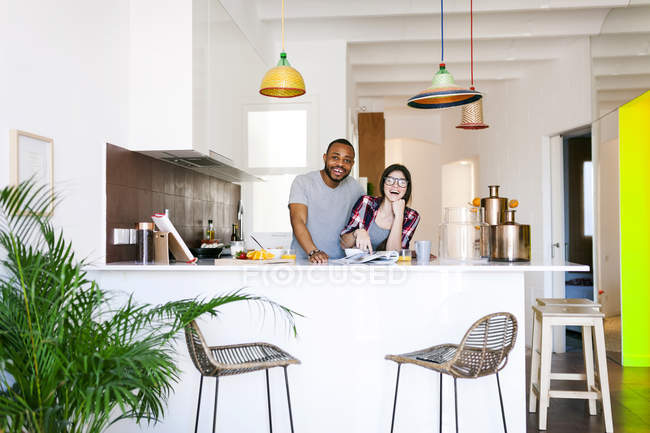 Retrato de jovem casal rindo na cozinha — Fotografia de Stock