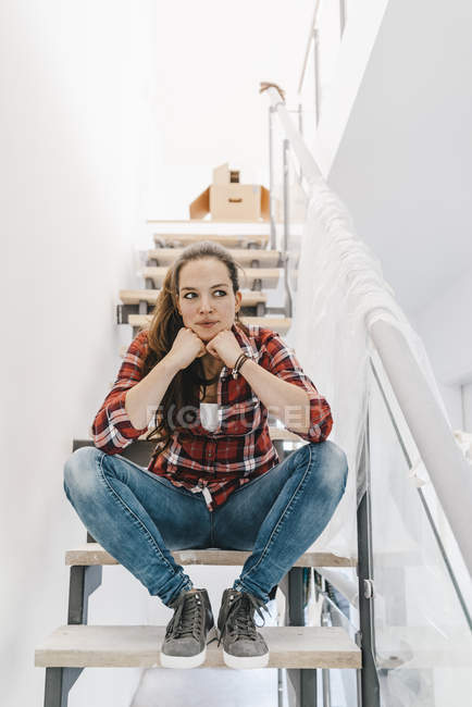 Зріла жінка сидить на сходах в новому будинку — стокове фото