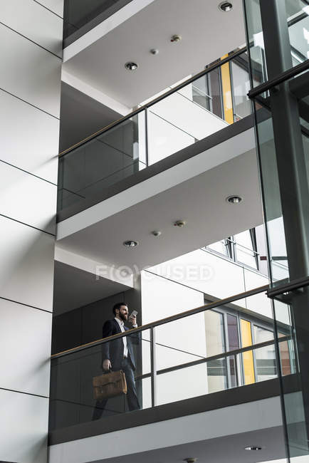 Porträt eines jungen Geschäftsmannes mit Smartphone im Hausflur — Stockfoto