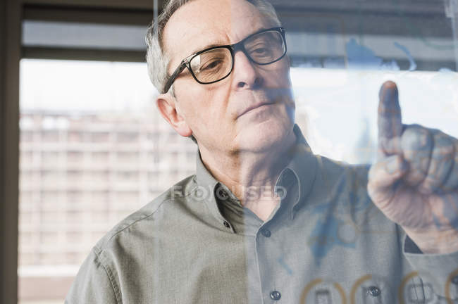 Abgeschnittenes Porträt eines Geschäftsmannes, der Glasscheibe berührt — Stockfoto