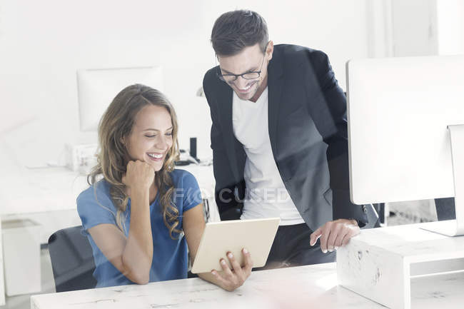 Jeune homme et jeune femme travaillant ensemble au bureau — Photo de stock