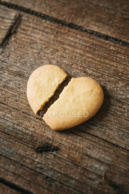 Herzförmig gebrochener Keks auf dunklem Holz — Stockfoto