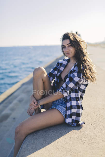 Портрет молодої жінки, сидячи на гавань — стокове фото