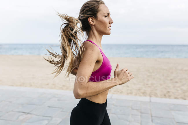 Jeune femme confiante courir à la plage — Photo de stock