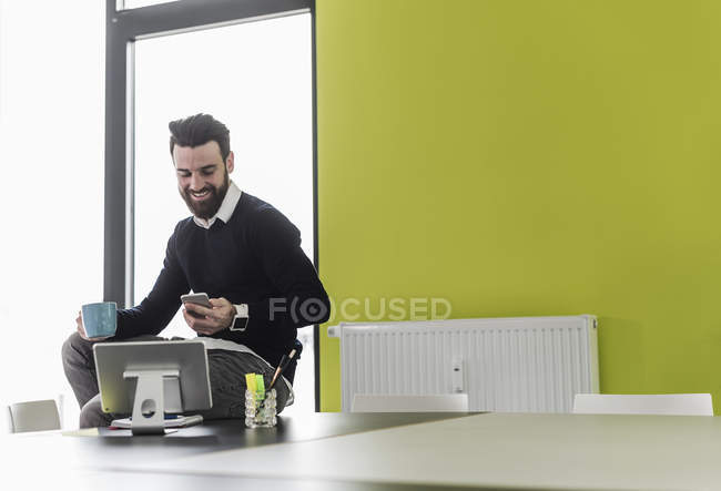 Porträt eines jungen Geschäftsmannes mit Smartphone — Stockfoto