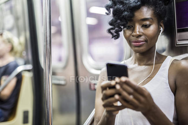 Обрізаний портрет жінки, що використовує смартфон у поїзді метро — стокове фото