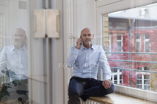 Mature caucasian man talking on mobile phone — Stock Photo