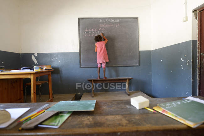 Madagascar, fianarantsoa, schülerin schreibt an tafel in der grundschule — Stockfoto