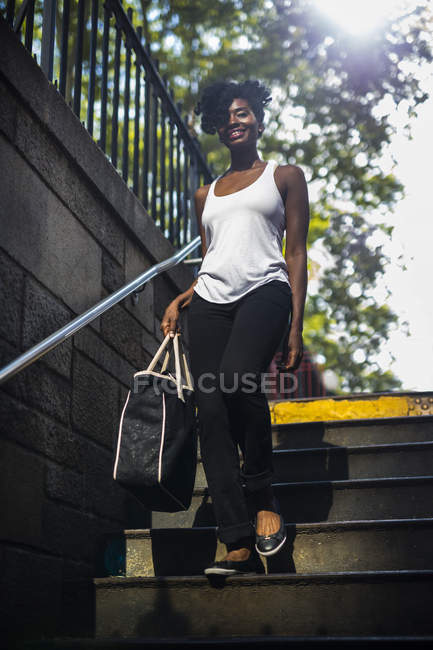 Retrato de la mujer caminando abajo con el bolso - foto de stock
